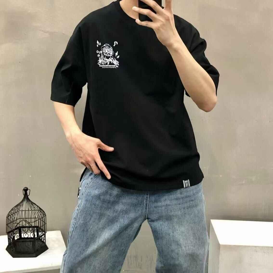Casual outfit with black graphic t-shirt, small white print on chest, and blue jeans.