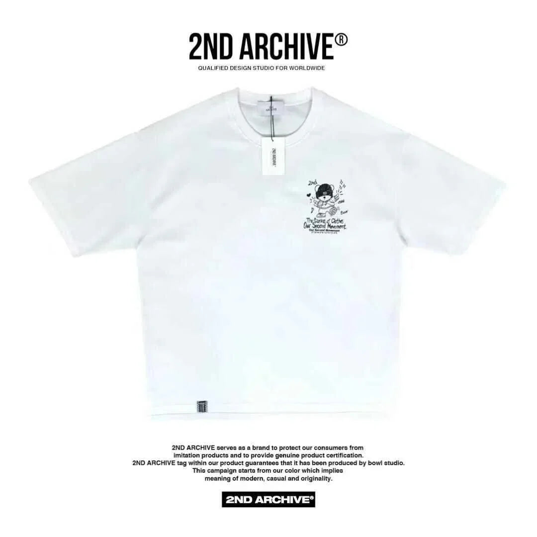 White 2ND ARCHIVE t-shirt with small cartoon graphic and text on left chest, flat lay view.
