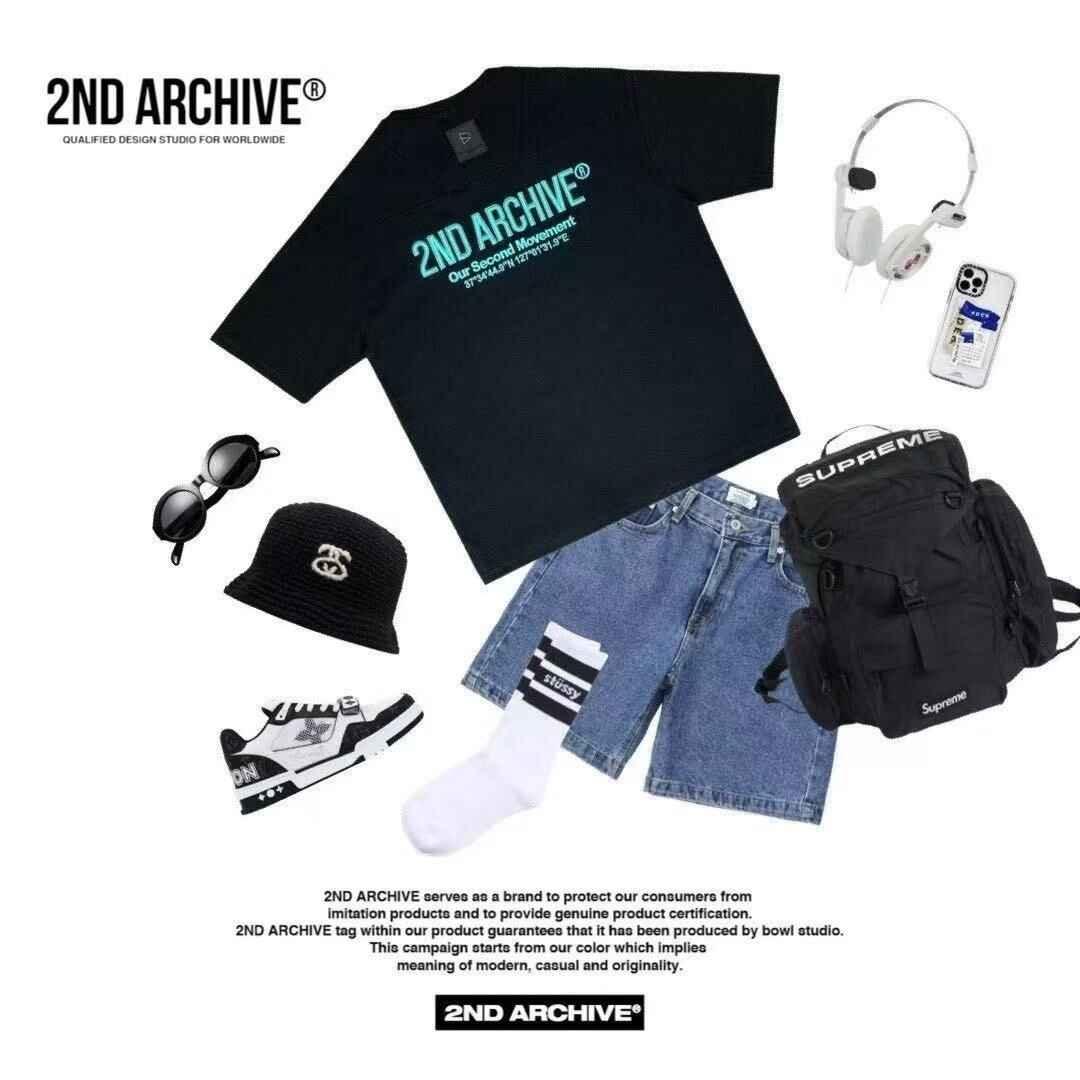 Black 2nd Archive logo short-sleeve tee with denim shorts, backpack, hat, sneakers, sunglasses, socks, headphones, and smartphone accessories in a flat lay style.