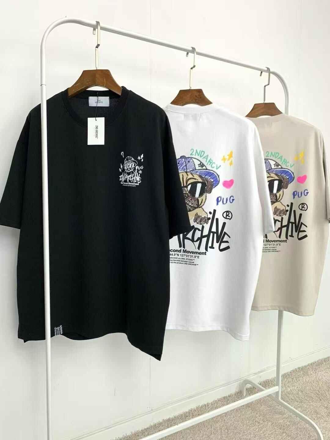 Three graphic t-shirts in black, white, and beige with cartoon pug and &