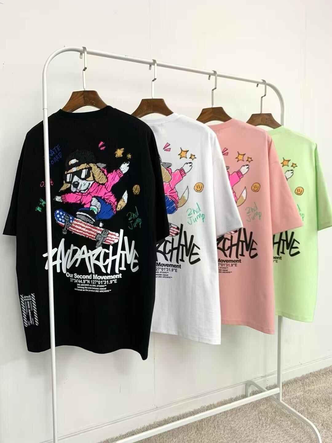 Colorful graphic tees with cartoon skateboarding dog print hanging on rack, streetwear fashion
