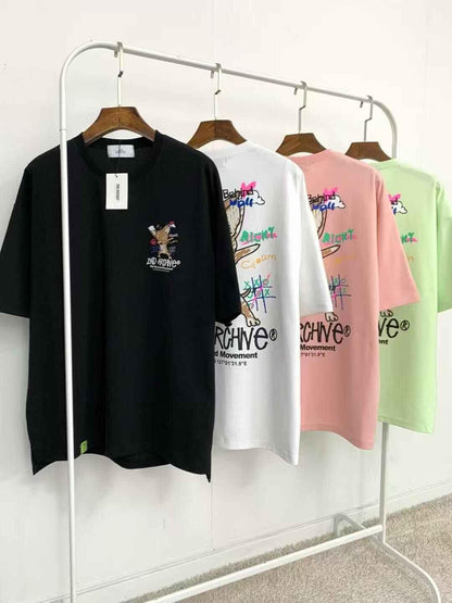 Trendy graphic t-shirts in black, white, pink, and green with cartoon fox logo on hangers