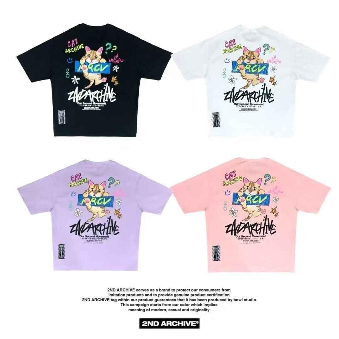 Four colorful cat graphic crayon tees in black, white, lilac, and pink, laid flat.