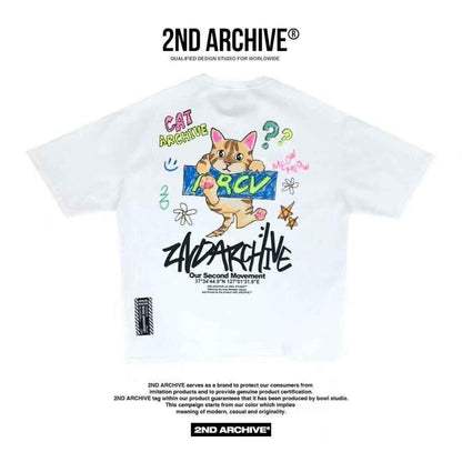 White graphic tee featuring a cartoon cat illustration, colorful doodles, and bold &