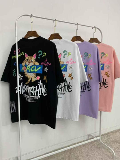 Cat graphic crayon-style T-shirts in black, white, purple, and pink hanging on a rack