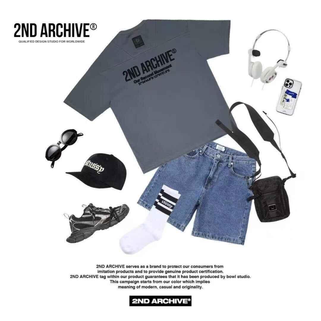 Flat lay of streetwear outfit with black graphic tee, denim shorts, sneakers, cap, sunglasses, and accessories.