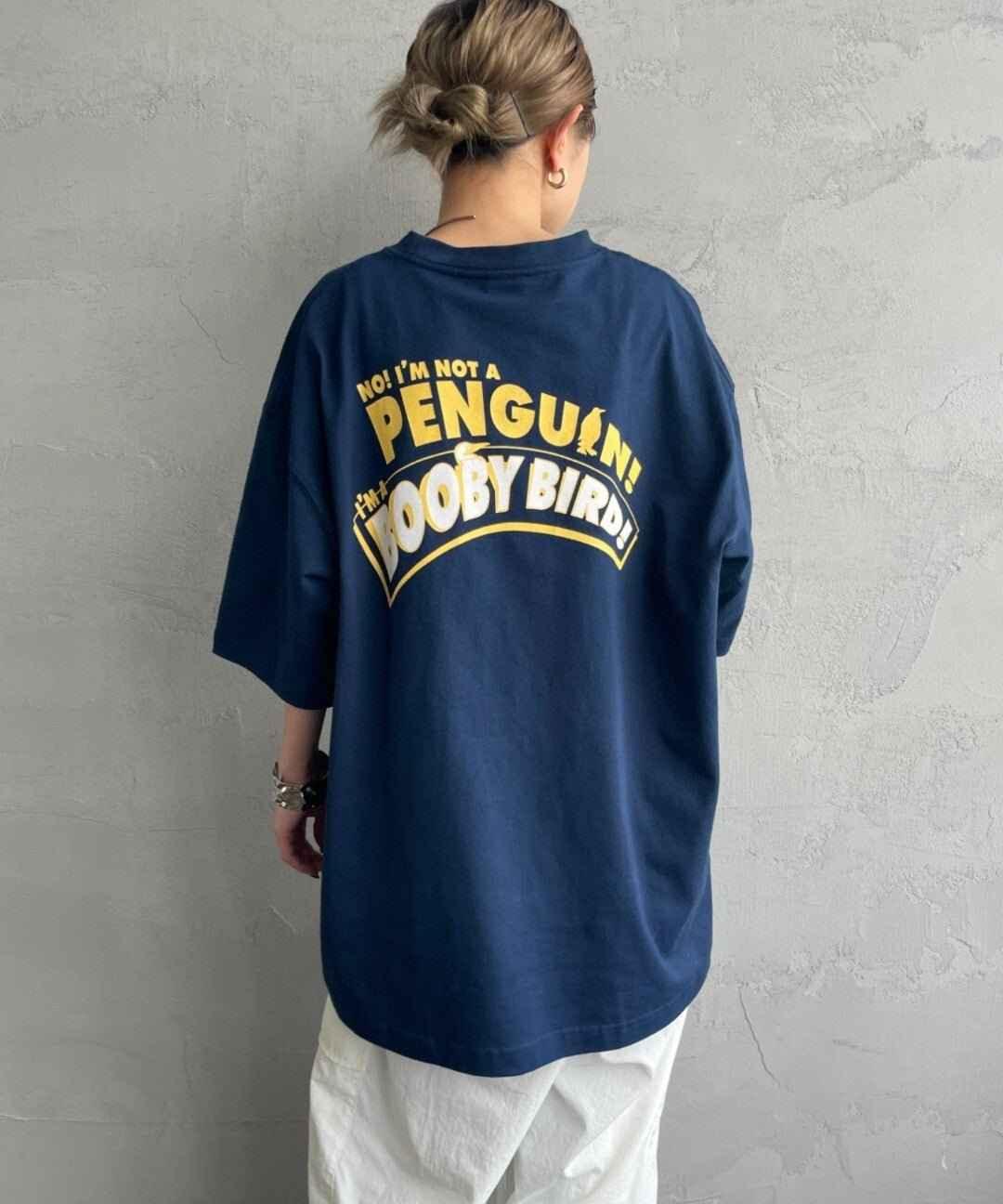 Woman wearing navy oversized tee with yellow &