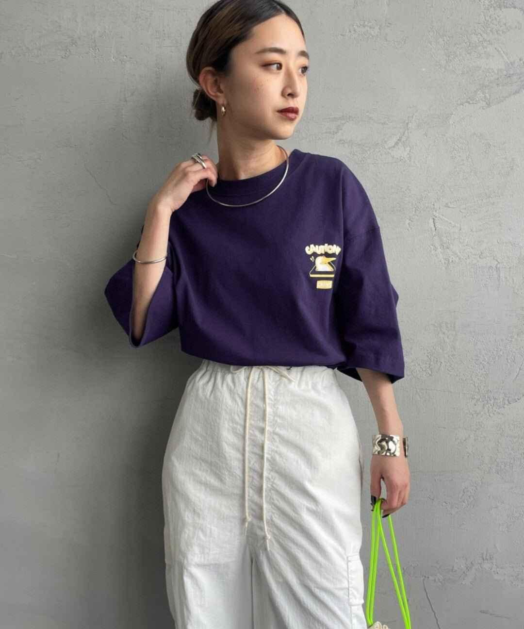 Woman wearing purple graphic tee with &