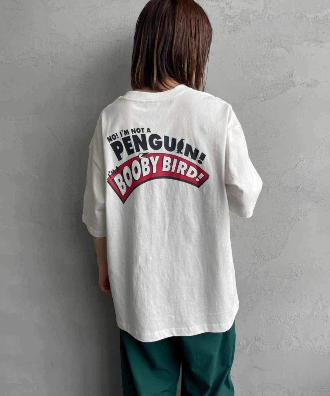 Person wearing white oversized t-shirt with No! I&